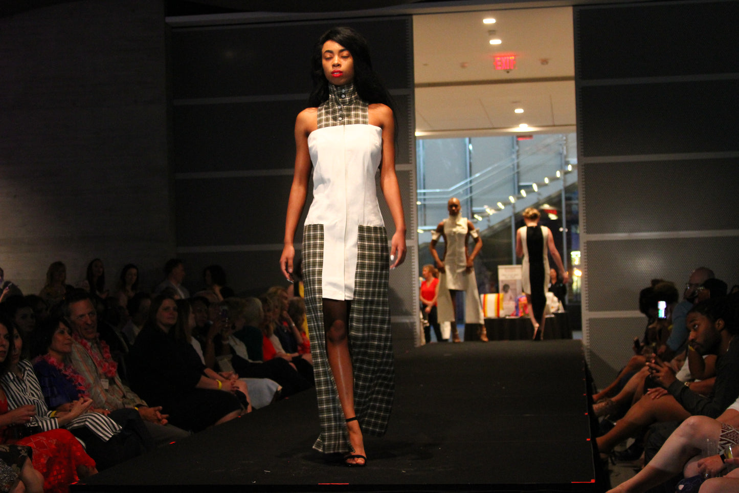 Anastasi Fashion design – Plaid And Denim Shirt Dress (Front): A model is wearing a white denim and cotton plaid dress with a zipper in the front and side pockets. The dress features a round neckline and a maxi skirt length.